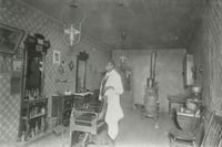 Black and white photograph of African American barber Prince Honeycutt in his Fergus Falls shop, c.1900.