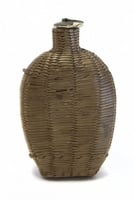 Wicker covered glass canteen.