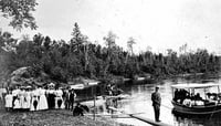 Photograph of a gathering of people on the banks of the upper Mississippi River for a prayer meeting conducted by Reverend John Sornberger c.1910.