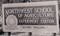 Black and white photograph of the entrance sign for the Northwest School of Agriculture and Northwest Experiment Station.