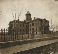 Black and white photograph of the first capitol building, ca. 1873.