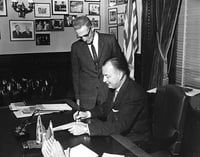 Black and white photograph of Governor Elmer Benson signing a bill with Grange Master William B. Pearson looking on, 1963. Photographed by Eugene Debs Becker.