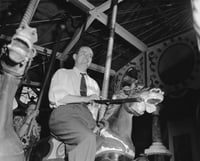 Black and white photograph of Hubert Humphrey riding the merry-go-round at the Minnesota State Fair, 1947.