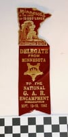 Ribbon worn by Albert Woolson at the national Grand Army of the Republic (GAR) encampment in Indianapolis held between September 13 and 18, 1942. Attached to the maroon ribbon is a matching Minnesota pin with a gopher that reads, Minnesota in the Land of 10,000 lakes and The Gopher State. The ribbon was donated by his daughter, Frances Campbell, to the St. Louis County Historical Society in Duluth.
