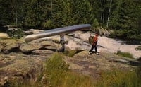 Color image of a group portaging a canoe in the Boundary Waters, ca. 1980.