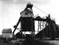 Black and white photograph of an iron ore shaft and stock pile in Virginia, Minnesota, 1915.