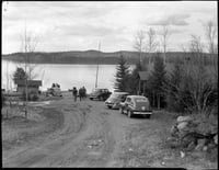 A view of cars, visitors, and Gunflint Lake at Gunflint Lodge. Photograph by Kenneth Melvin Wright, ca. 1950.
