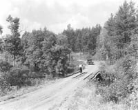 Car approaching a bridge with pedestrians along the Gunflint Trail. Photograph by William F. Roleff, 1936.