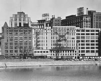 Black and white photograph of the West Publishing complex seen from the Mississippi River, 1955.