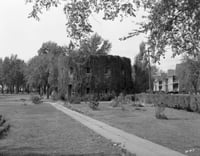 Black and white photograph of the Round tower covered in vegetation,1935. Photographed by Norton and Peel.