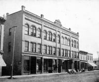 Black and white photograph of the façade of the Opera House Block on South Main Street as it looked in 1910.