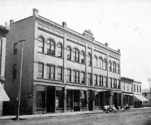 Black and white photograph of the façade of the Opera House Block on South Main Street as it looked in 1910.