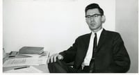 Black-and-white photograph of Professor Roy W. Meyer at his Mankato State College desk in the early 1960s.