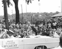 Black and white photograph of Eugene McCarthy in a parade, with daughters Ellen, Mary, and Margaret McCarthy, c.1964.