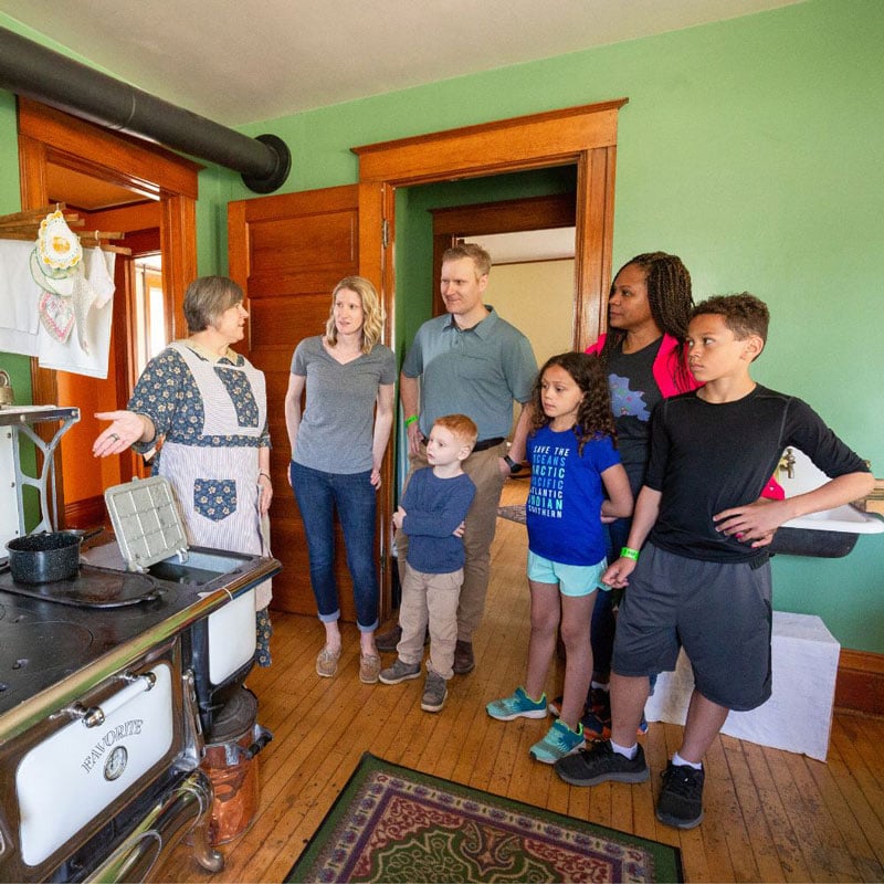 A guide is showing visitors around the kitchen at Split Rock Lighthouse.