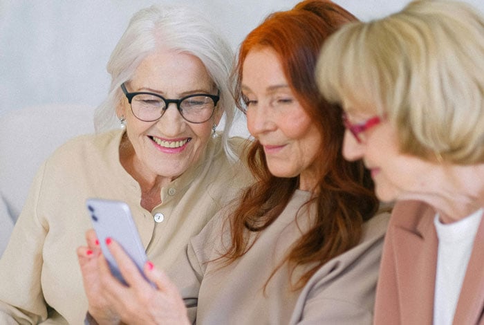 Elderly happy women browsing internet while searching for information.