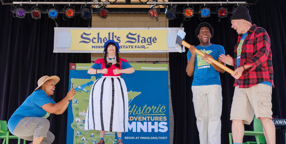 Three people perform on a stage.