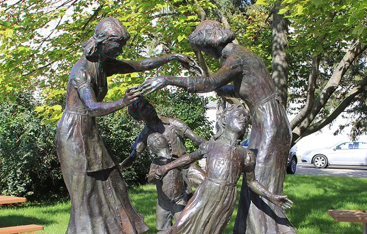 Statue titled &quot;The Mothers&quot; where two mothers play with their children.