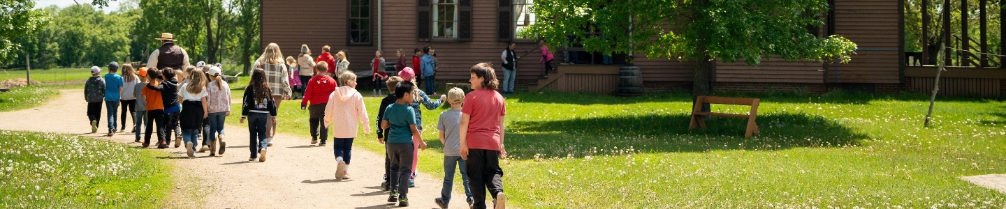 Children in a line following interpreter at Oliver Kelley Farm Children in a line following interpreter at Oliver Kelley Farm