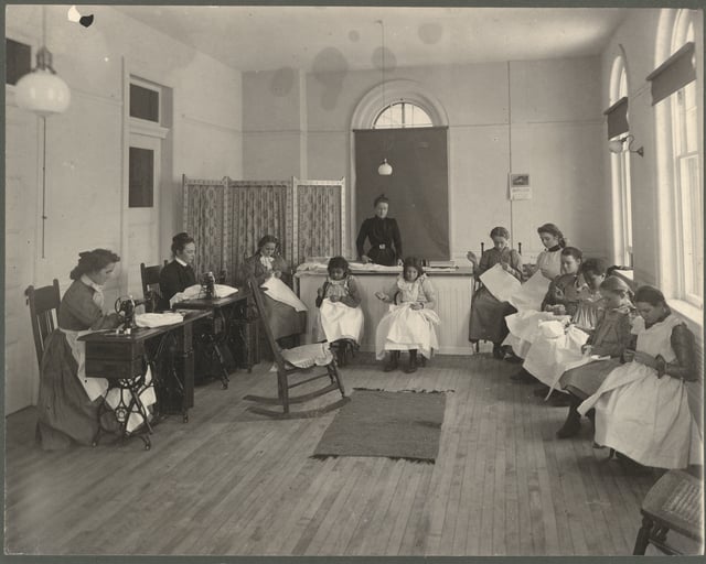 Black and white photograph of sewing class at the State School, c.1905.