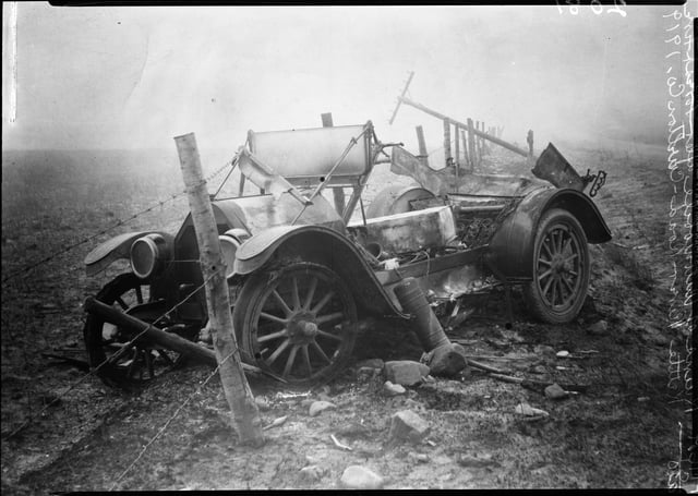 Black and white photograph of the ruins of a car after fire, Kettle River Road, 1918.