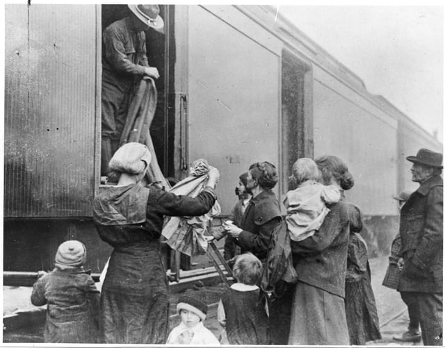 Black and white photograph of the National Guard giving out clothing to refugees, 1918.
