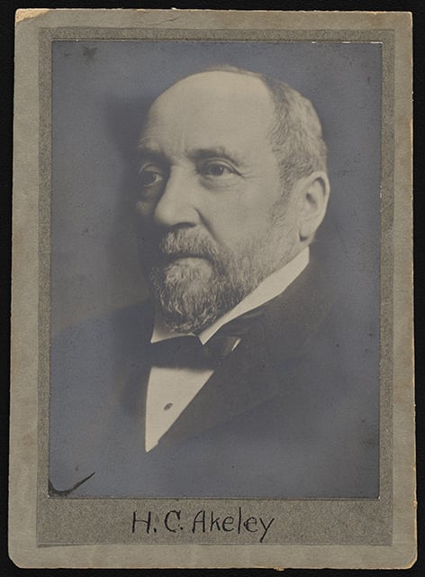 Three-quarters view of a man's head and shoulders. He is partly bald, with a beard and moustache, and wears a suit jacket, tie, and white shirt.