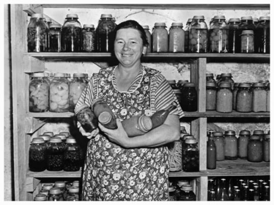 Woman with canned vegetables, part of Farm Security Administration program.