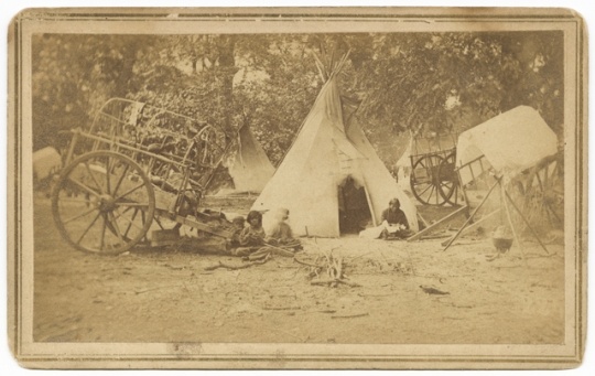 Black and white photograph of a Red River cart at a Dakota family’s camp, ca. 1870.