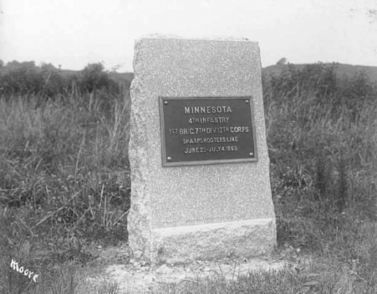 Photograph of a rectangular stone monument with metal plaque honoring the Fourth Minnesota regiment