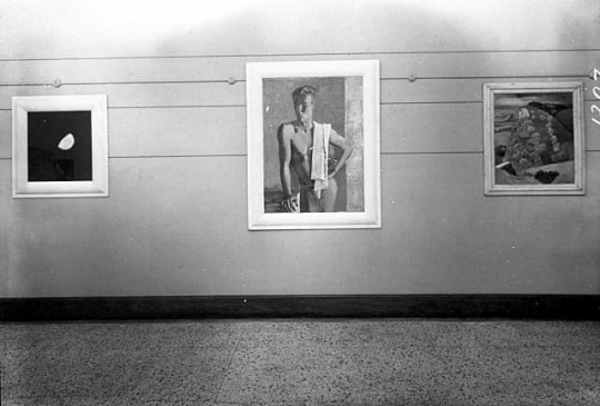 Black and white photograph of paintings by Clement Haupers on exhibit, c.1940.