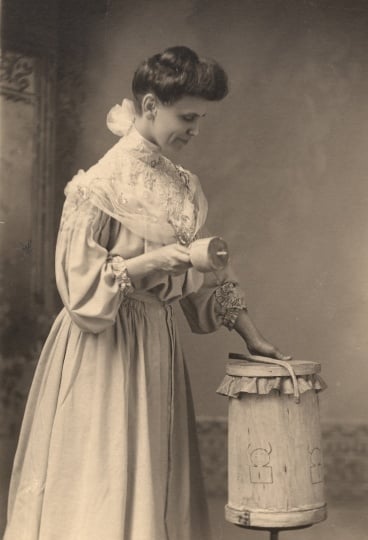 Black and white photograph of Frances Densmore with American Indian instruments.