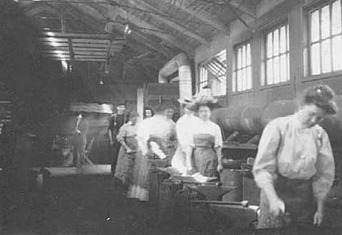Black and white photograph of an Agriculture Extension, short course in Blacksmithing women at the forges, 1908.