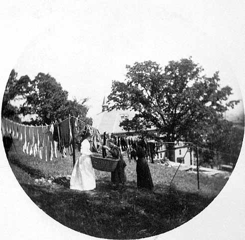 Black and white photograph entitled Hanging up the clothes at the James J. Hill House, 240 Summit, St. Paul, c.1900.