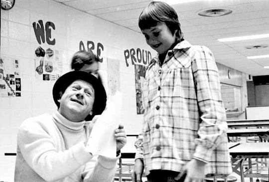 Black and white photograph of television character Roundhouse Rodney (played by Lynn Dwyer on WTCN) signing an autograph for a young fan, c.1961.