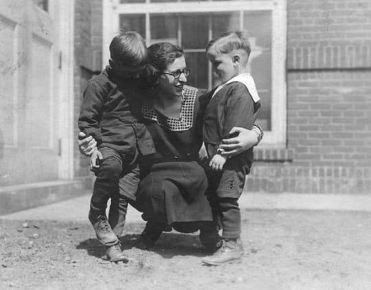 Black and white photograph of a woman with two boys at the Northeast Neighborhood House, c.1925.