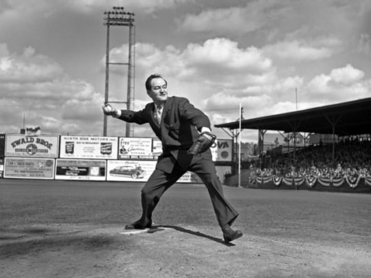 Black and white photograph of Minneapolis Mayor Hubert Humphrey throws out the first pitch of a baseball game played by the Minneapolis Millers at Nicollet Park in Minneapolis on April 27, 1948.