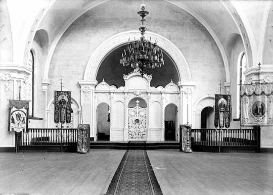 Black and white photograph of the interior of the sanctuary in St. Mary’s Orthodox Cathedral, Minneapolis with an icon screen and banners, c.1906.