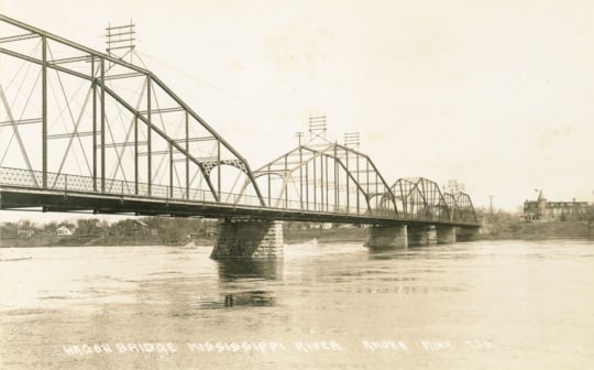 Black and white postcard image of the Anoka–Champlin Mississippi River Bridge, originally built in 1884, ca. 1920.
