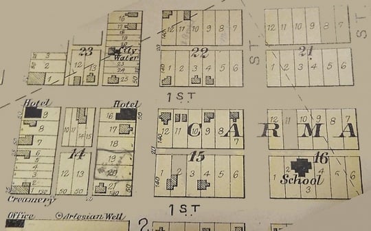 Photograph of page in Polk County plat book (1902) showing locations of Carman’s creamery, hotels, school, and artesian wells.