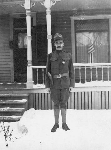 Black and white photograph of A. A. Baker, member of the Minnesota Home Guard, 1917. The star he wears designates him as a special deputy sheriff sworn in during the Streetcar Workers Strike.