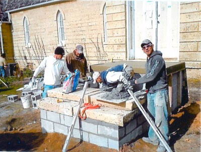 Four workers setting stone steps