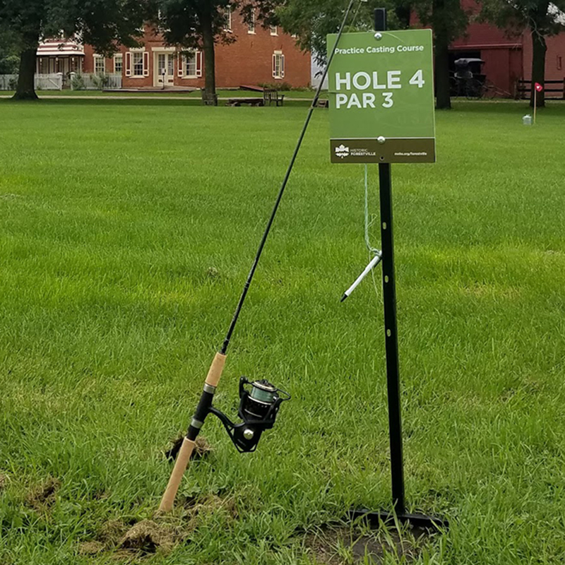 A fishing pole leaning up against a sign.