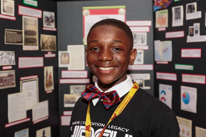 A student stands in front of a project display.