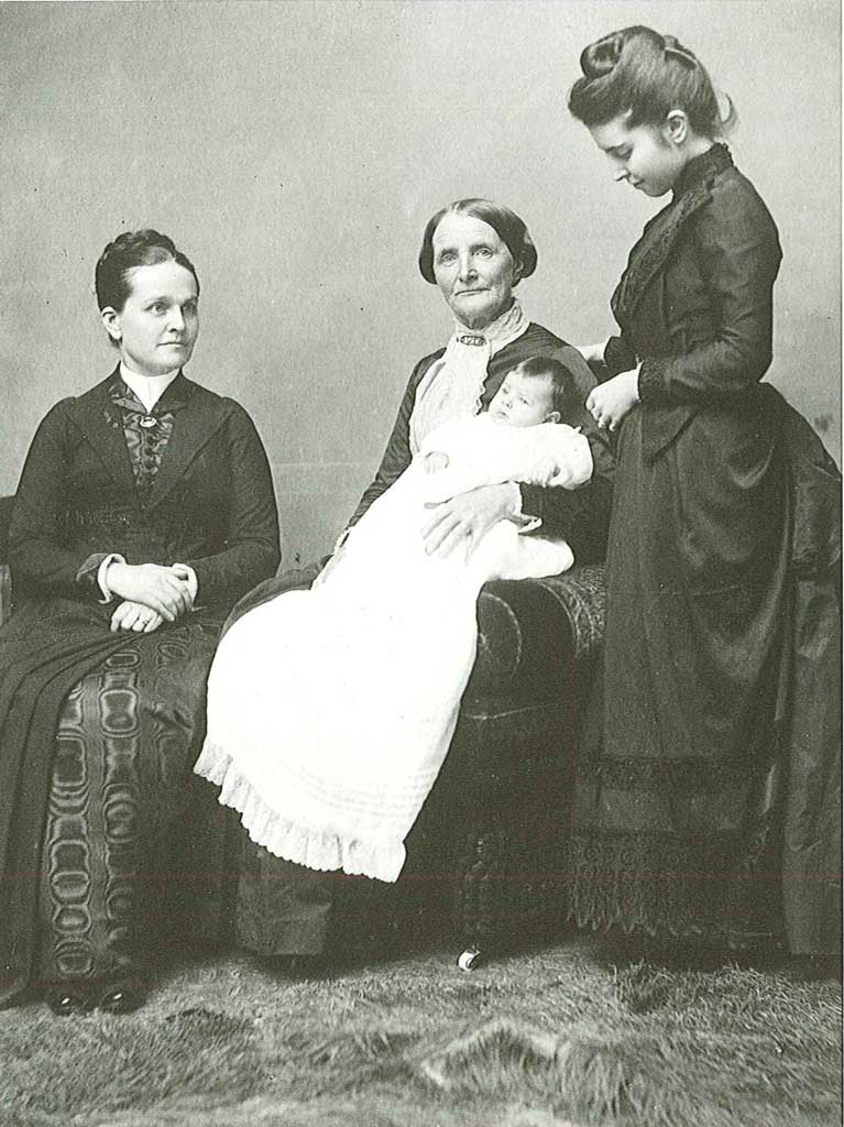 Mary T. Hill on the left, her mother holding a baby, and Mamie Hill on the right, looking at the baby