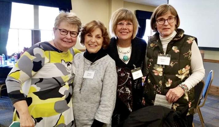 Four women smiling.