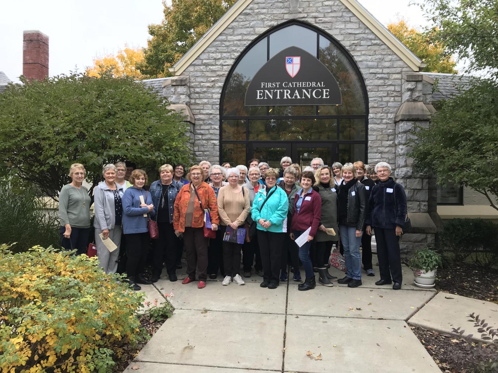 A group of women standing in front of a church.