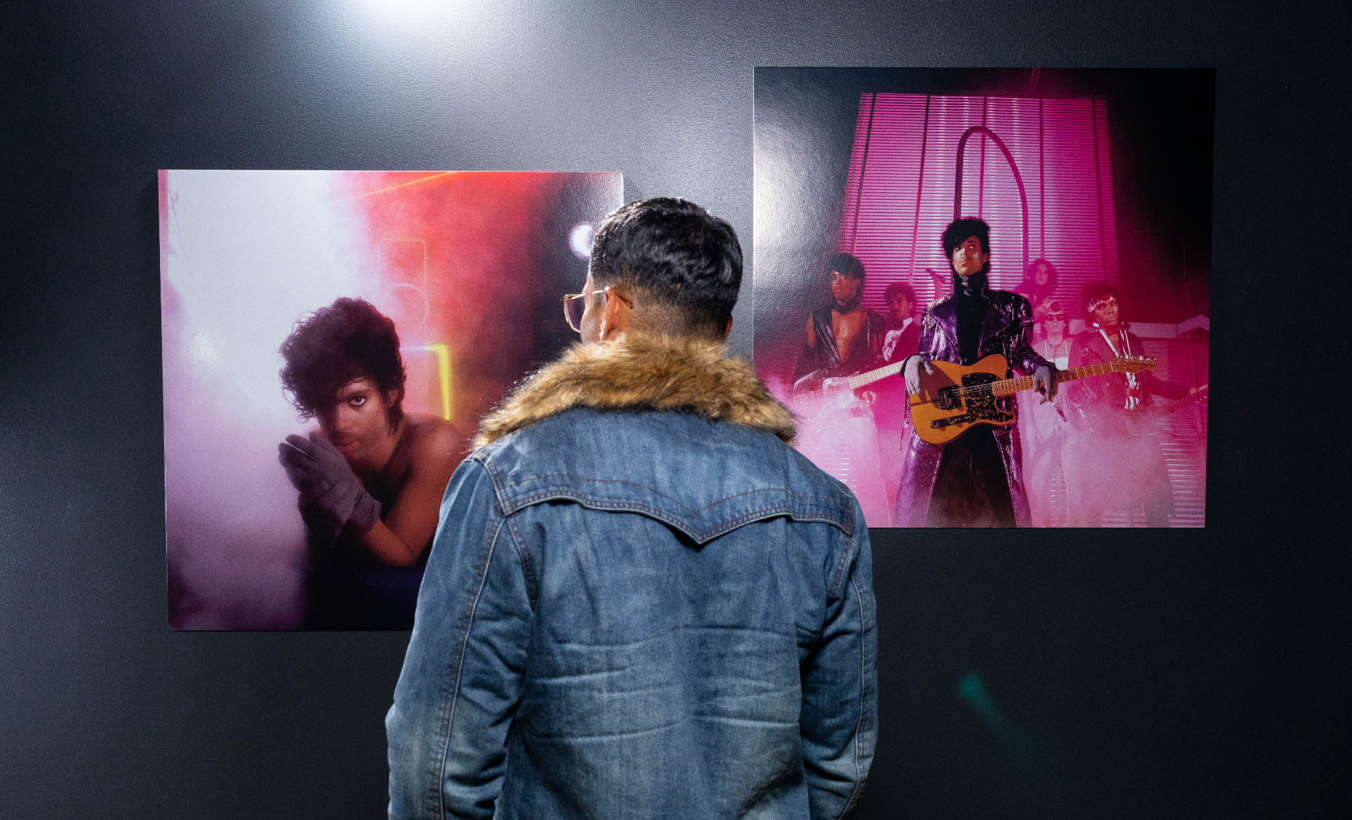 Man looking at photos in Prince Exhibit.
