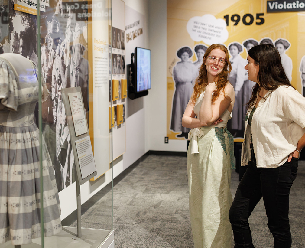 Two women looking at an exhibit panel.