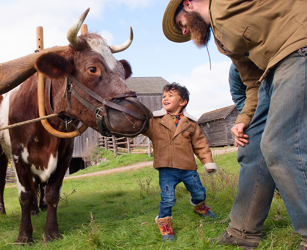 Boy petting a beast of burden.